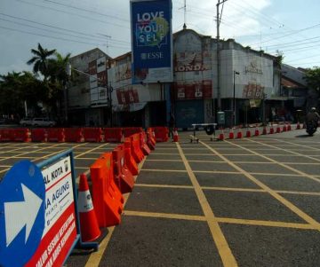 Kendaraan melintas samping pembatas jalan di kawasan perempatan Alun-alun Kota Tegal, Jawa Tengah, Jumat (27/3/2020). Sejak diberlakukan penutupan jalan masuk ke Alun-alun Kota Tegal dan pengalihan jalur di sejumlah jalan protokol untuk antisipasi penyebaran COVID-19 lima hari lalu, jalanan di pusat kota llengang dan penjualan sejumlah toko dan rumah makan diperkirakan menurun hingga 80 persen. ANTARA FOTO/Oky Lukmansyah/nz